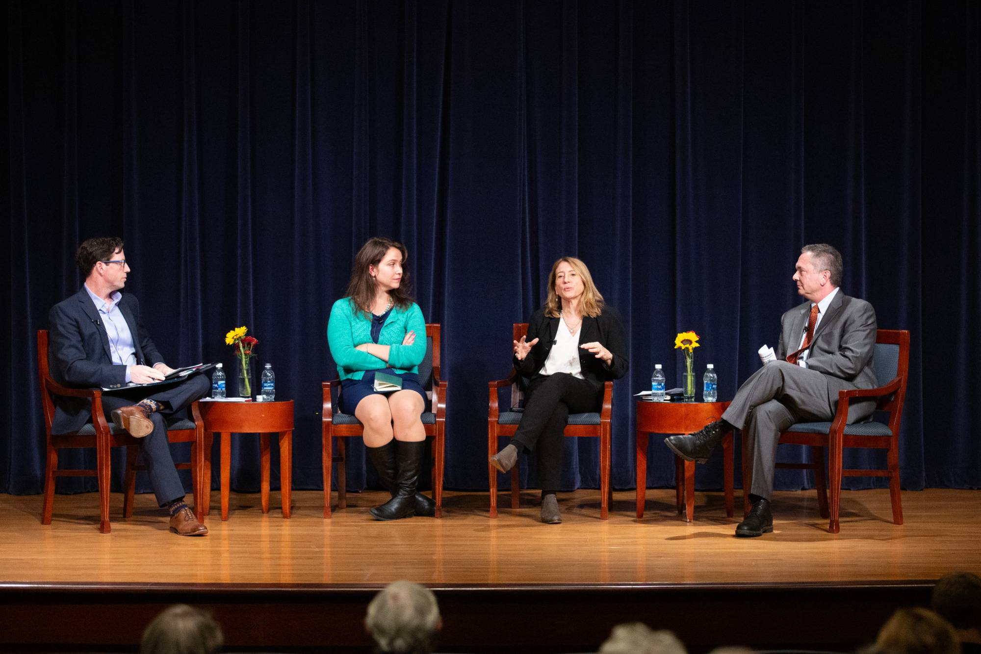 four people sit on a stage for a panel discussion